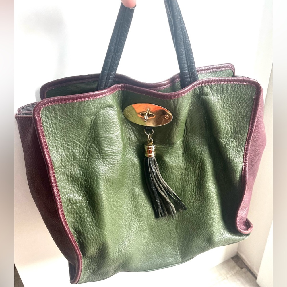 Olive and burgundy leather handbag with black straps.